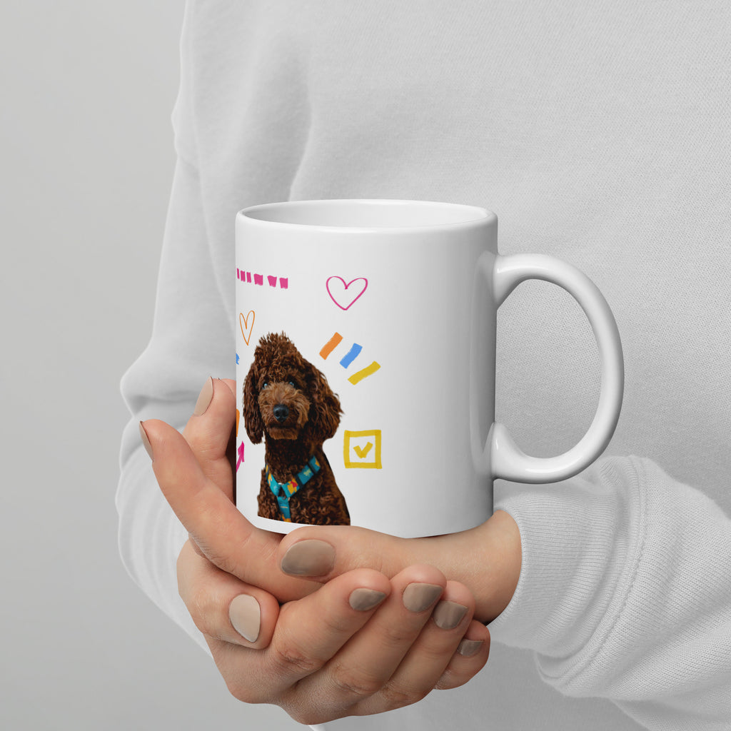 This custom white ceramic mug features an adorable brown poodle portrait surrounded by playful hand-drawn doodles, including hearts, checkmarks and colourful marker strokes.
Vibrant, whimsical decorations wrap around both sides of the cup, making it a sweet personalized gift for dog lovers.
Perfect for enjoying your morning coffee while showing off your love for your furry friend.
